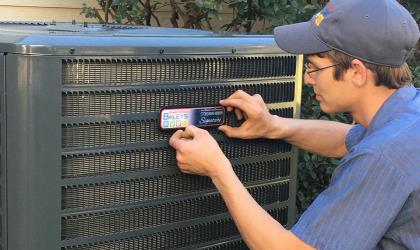 Technician working on an outdoor AC condenser coil