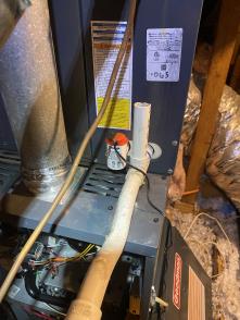 Picture of a Bailey's Comfort Services techician fixing the furnace control board